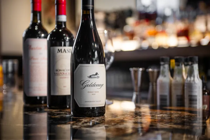 Bottles of red wine lined up on the bar at Andino's Restaurant