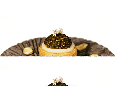 Small masa tart topped with caviar and a flower at Californios