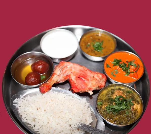 An Indian thali at India Palace in Memphis with tandoori chicken, dal, butter chicken, saag, basmati rice, raita and gulab jamun on a steel platter