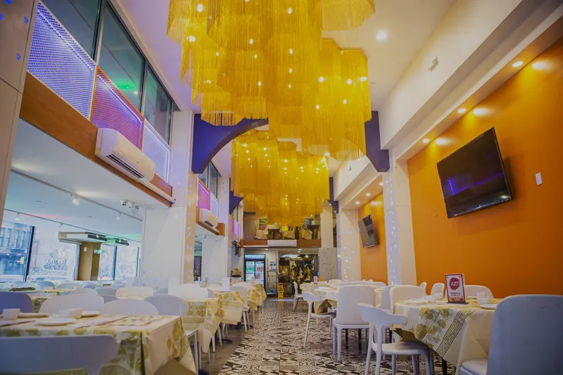Bright two-story dining room at Hei La Moon in Boston Chinatown with gold chandeliers and set tables