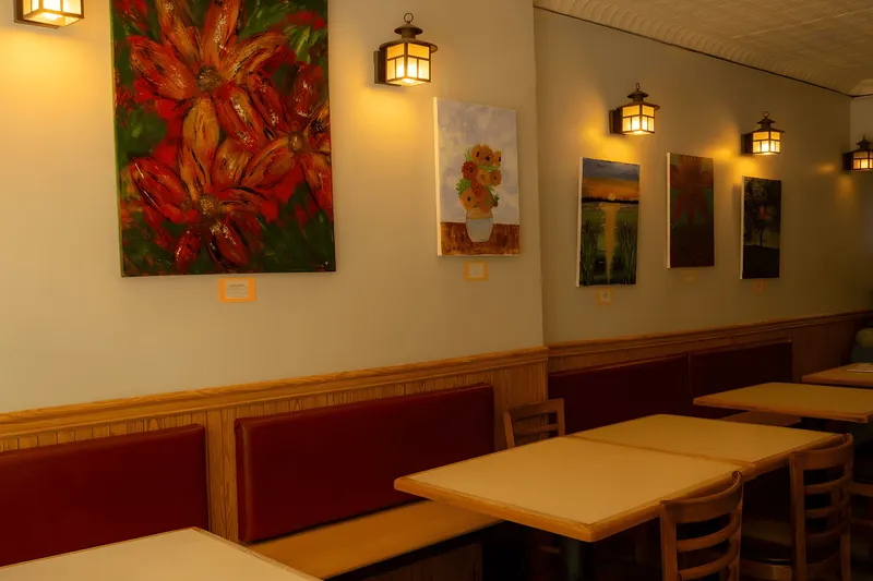 Dining room interior at Sern Sapp Restaurant with local artwork on the walls