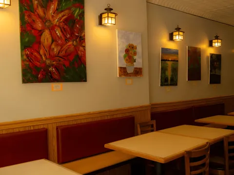Dining room interior at Sern Sapp Restaurant with local artwork on the walls