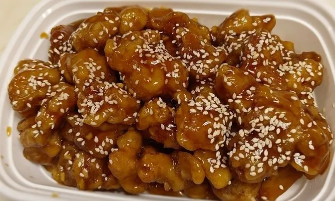 Sesame chicken in a glossy brown sauce topped with sesame seeds at Golden Crown Restaurant in Atlanta