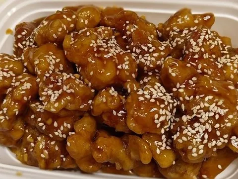 Sesame chicken in a glossy brown sauce topped with sesame seeds at Golden Crown Restaurant in Atlanta