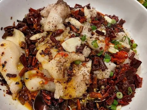 Sichuan boiled fish fillet with Szechuan peppercorns and dried chilies in a white bowl at Masterpiece