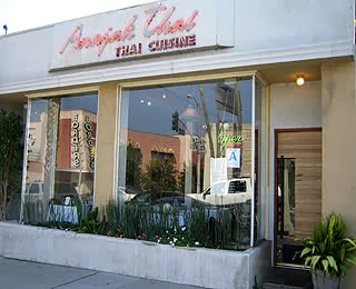 Street-facing entrance and neon Thai Cuisine sign at Anajak Thai