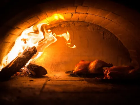 Whole chickens roasting in Zuni Cafe's wood-fired oven