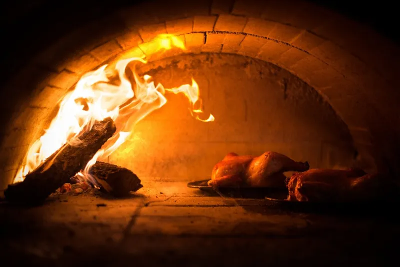 Whole chickens roasting in Zuni Cafe's wood-fired oven