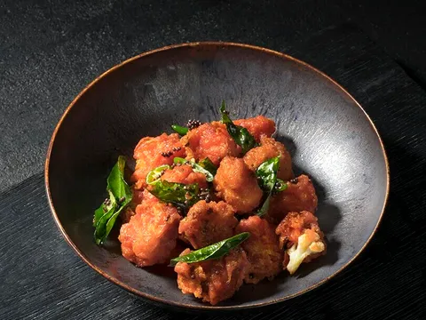 Cauliflower Bezule with curry leaves in a dark bowl at Rasika