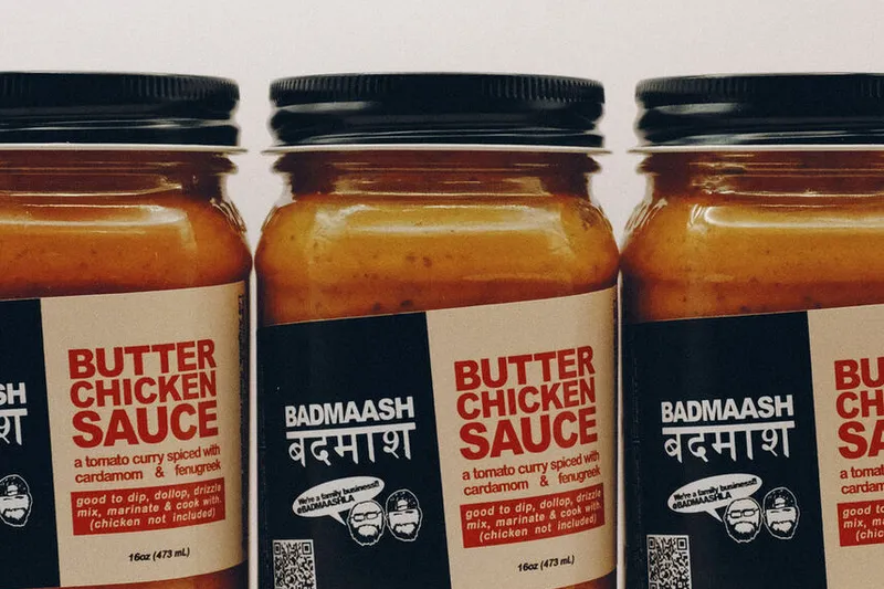 Three jars of Badmaash butter chicken sauce arranged on a white background