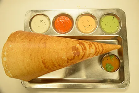 A cone masala dosa served with sambar and four chutneys on a steel tray at Sri Ananda Bhavan in Sunnyvale.