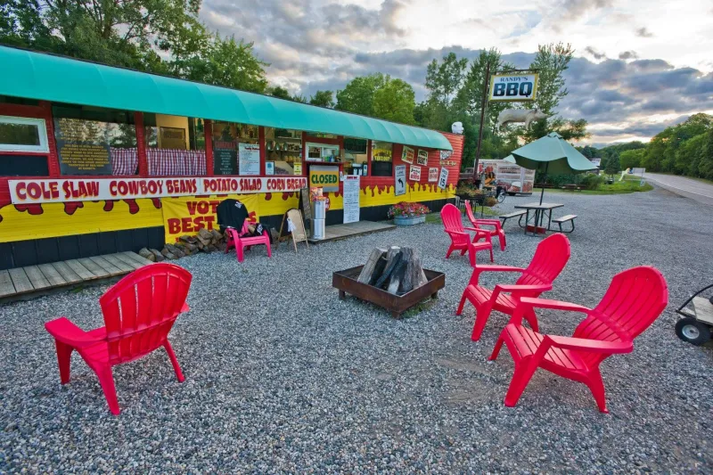 Exterior of Randy's BBQ with red patio chairs