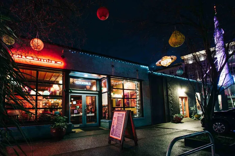 The El Camino storefront at night in Fremont, Seattle, with its glowing neon sign, strings of lights, paper lanterns and a lit "Cocktails" window at 607 N 35th Street