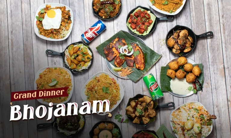 Overhead spread of Godavari's Grand Dinner Bhojanam — biryanis, dosas, tandoori fish, curries and fried appetizers in cast-iron skillets, promotional photo from Godavari in Woburn, Massachusetts