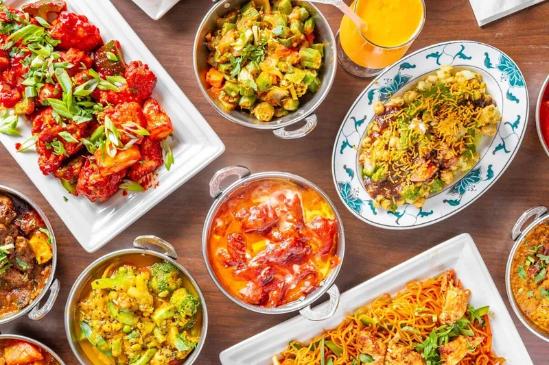 Overhead spread of Nepali and Indian curries, rice, bread, and appetizers at Nepal House