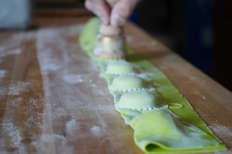 Fresh green ravioli being cut by hand at Gumba in Portland