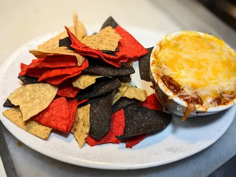 Plate of tri-colour tortilla chips with a baked dip at State Street Saloon