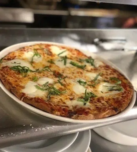 A margherita pizza topped with fresh mozzarella and basil at Cassarino's Ristorante