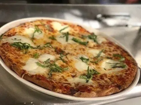 A margherita pizza topped with fresh mozzarella and basil at Cassarino's Ristorante
