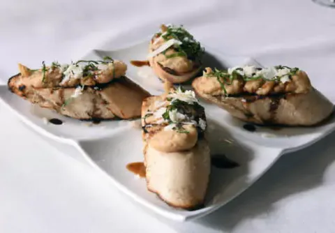 Bruschetta with goat cheese and oyster mushrooms on a white plate at Volare Italian Ristorante in Louisville