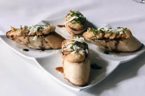 Bruschetta with goat cheese and oyster mushrooms on a white plate at Volare Italian Ristorante in Louisville