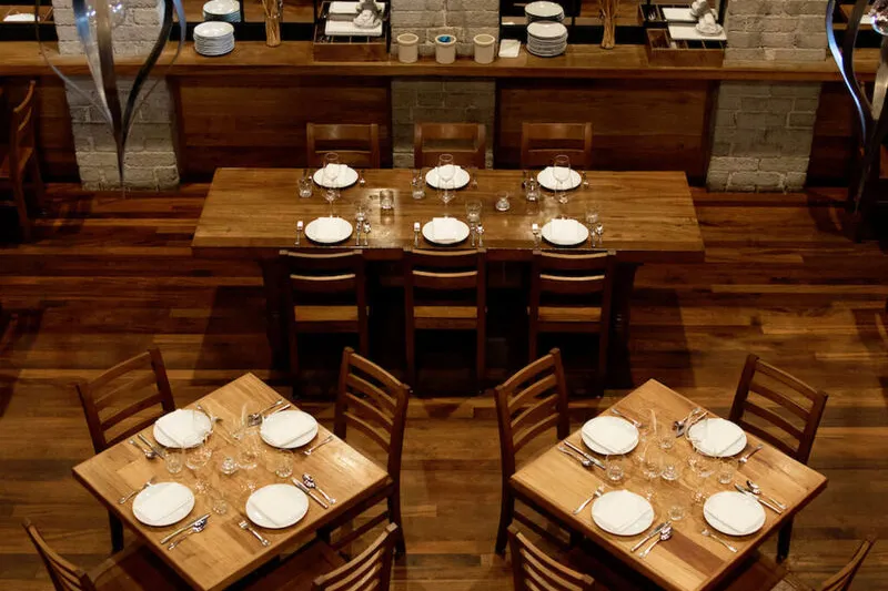 Tall brick dining room with set tables inside République in Los Angeles