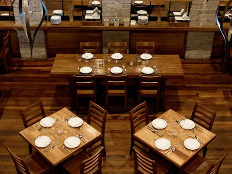 Tall brick dining room with set tables inside République in Los Angeles