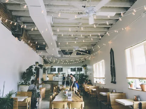 Bright dining room with wooden tables at Clavel Mezcaleria