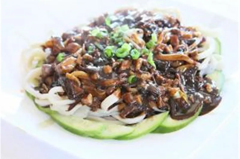 Handmade hand-pulled noodles topped with black bean sauce, minced pork and scallions over sliced cucumber at Frank's Noodle House