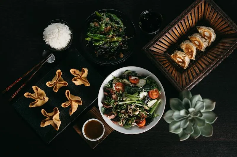 Overhead spread of dumplings, wontons, rice, greens, and salad at Heritage by Bo Lings.