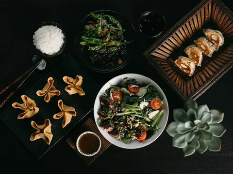Overhead spread of dumplings, wontons, rice, greens, and salad at Heritage by Bo Lings.