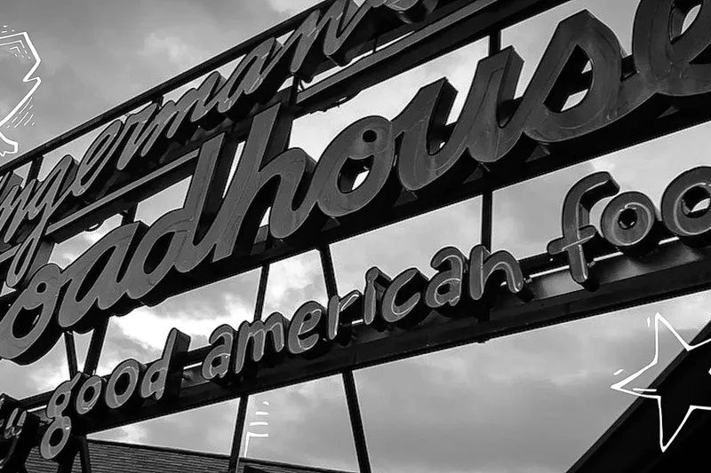 The Zingerman's Roadhouse rooftop neon sign reading 'really good american food' with the est. 2003 pig logo