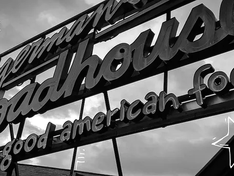 The Zingerman's Roadhouse rooftop neon sign reading 'really good american food' with the est. 2003 pig logo