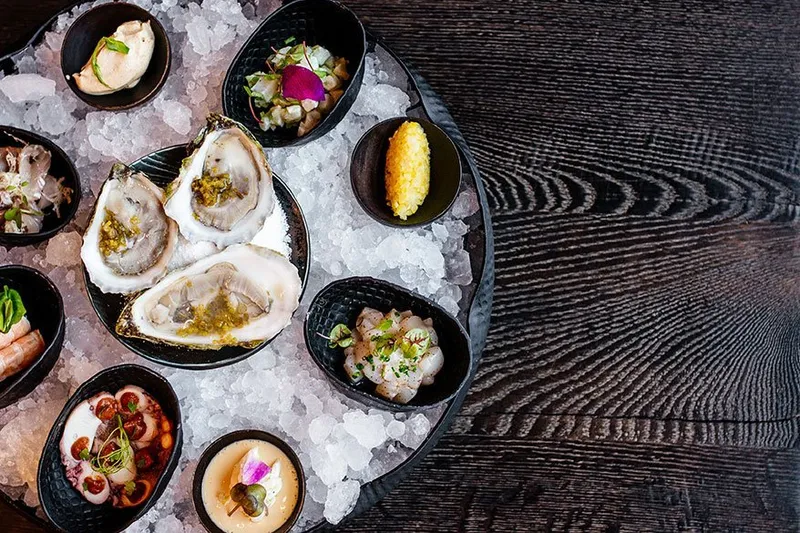 Bacchanalia fruits de mer seafood tower on crushed ice with oysters, shrimp, octopus and crudos