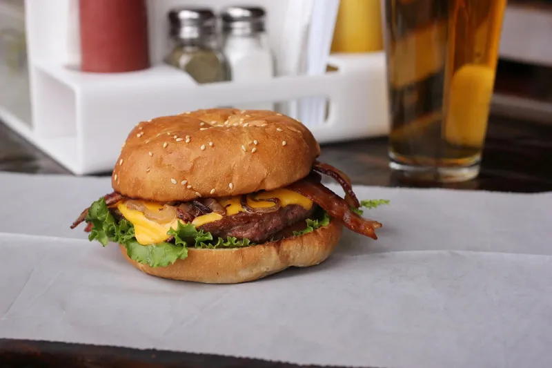 A bacon cheeseburger with lettuce on a sesame bun at My Brother's Bar