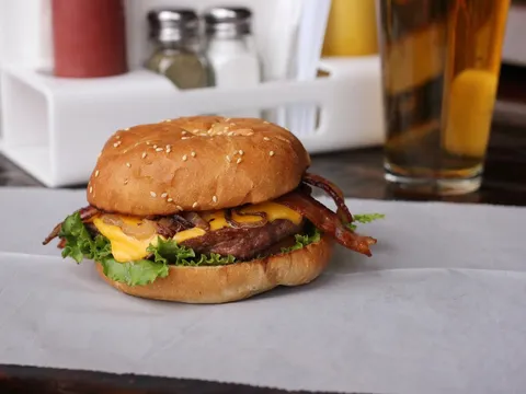 A bacon cheeseburger with lettuce on a sesame bun at My Brother's Bar