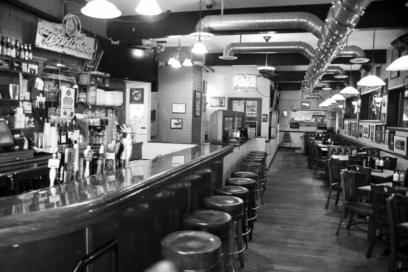 Black-and-white view down the bar and dining room at Casper's & Runyon's Nook in Saint Paul