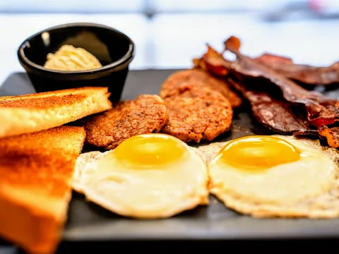 Breakfast plate of fried eggs, bacon, sausage patties and buttered toast at Quarrier Diner
