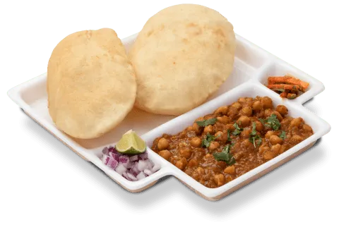 Neehee's chole bhature — spiced chickpea curry with two fried bhature, onions and lime on a serving tray