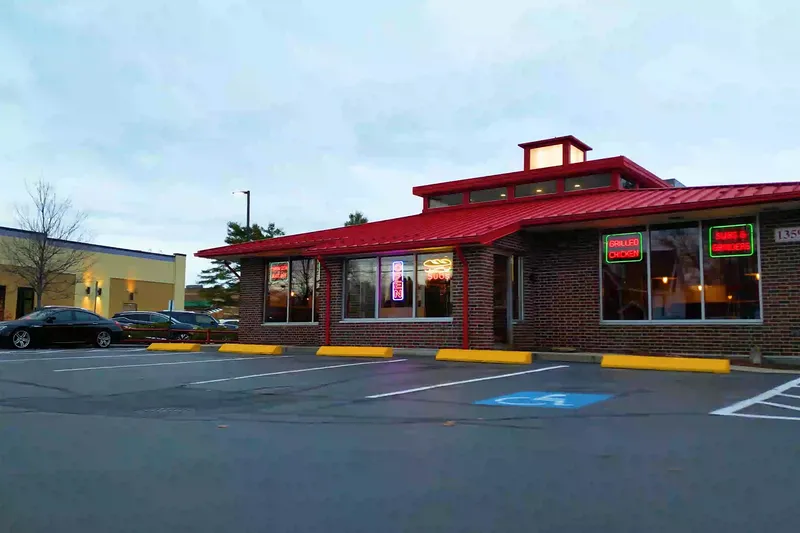 Red-roofed exterior of Portland House of Pizza at dusk, seen from the parking lot