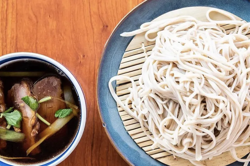 Kamonegi handmade soba noodles served beside duck dipping broth