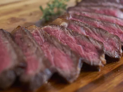 Sliced strip steak on a wooden board at Martin's Tavern