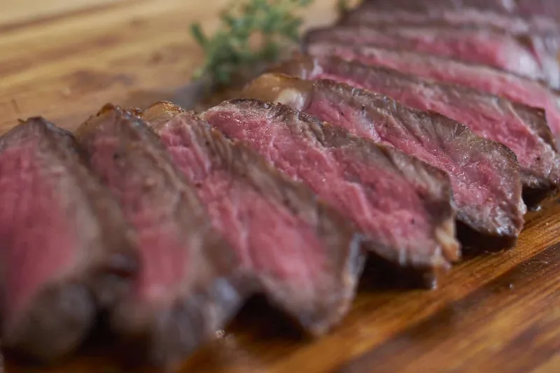 Sliced strip steak on a wooden board at Martin's Tavern