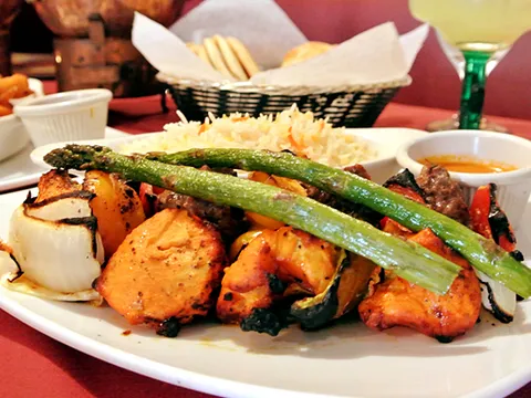 Tandoori mixed grill platter with chicken tikka, seekh kebab, grilled asparagus, onions and rice at Bombay Olive
