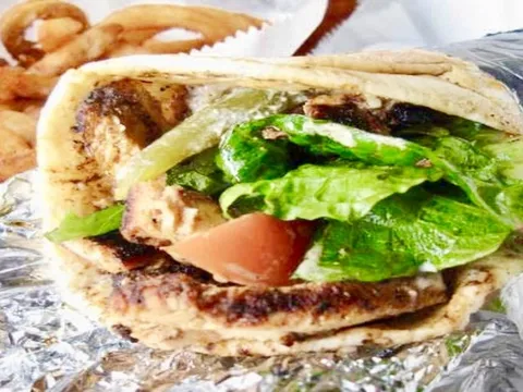 Chicken shawarma wrapped in pita with lettuce and tomato, served with curly fries at Bucharest Grill in Detroit