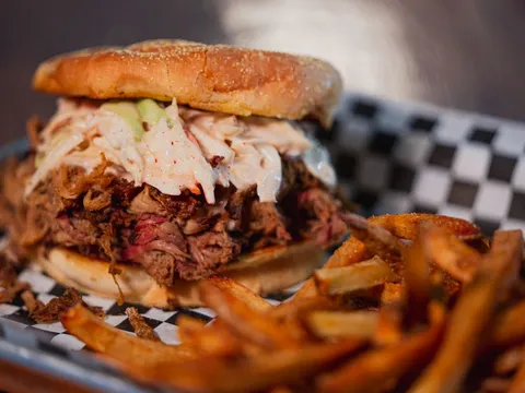 Pulled pork sandwich with coleslaw and fries at Delano Barbeque Company