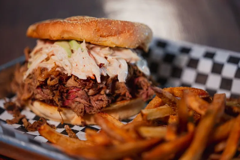 Pulled pork sandwich with coleslaw and fries at Delano Barbeque Company