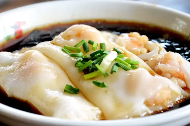 A shrimp rice noodle roll (cheong fun) topped with chopped chives in sweet soy sauce at Yin Ji Chang Fen