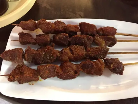 Grilled lamb skewers on a plate at Peking Alley