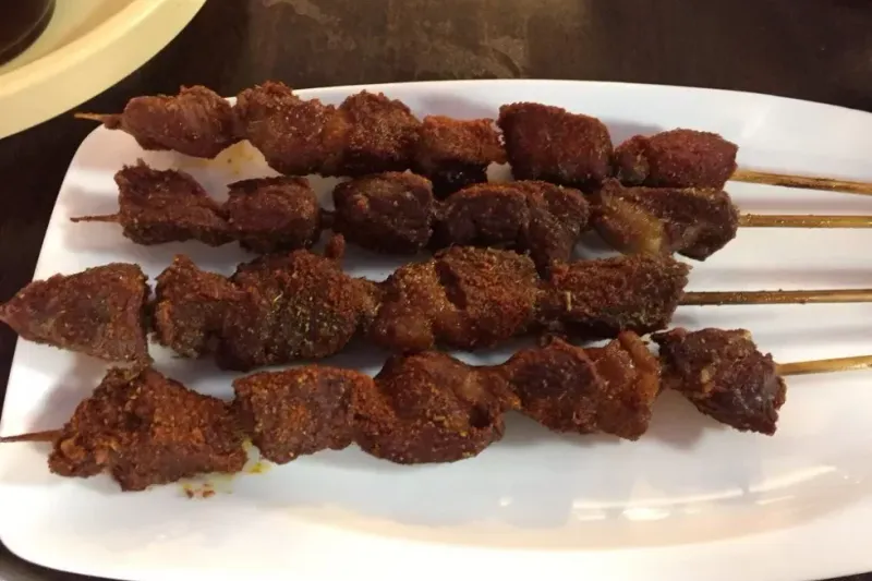 Grilled lamb skewers on a plate at Peking Alley